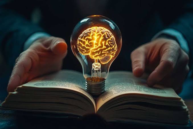 Glowing lightbulb with a brain inside an open book representing critical thinking in AI in digital marketing