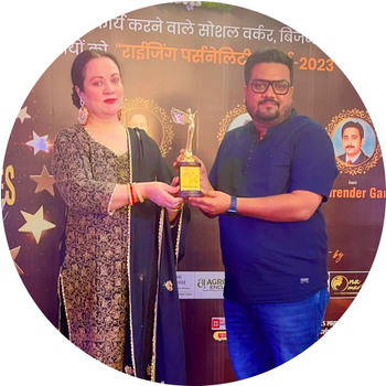 Man in a dark blue shirt receiving the Rising Personality Award golden trophy from a woman guest on stage.